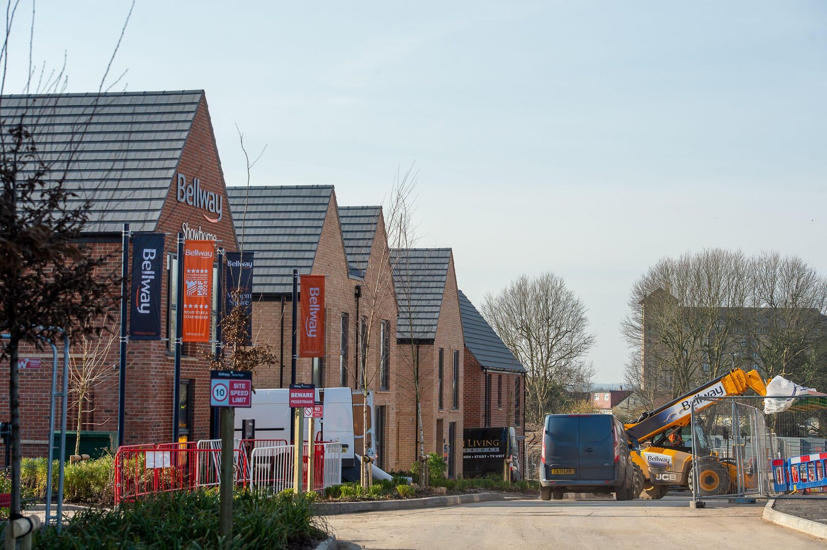 Construction workers building Bellway Homes apartments and houses.